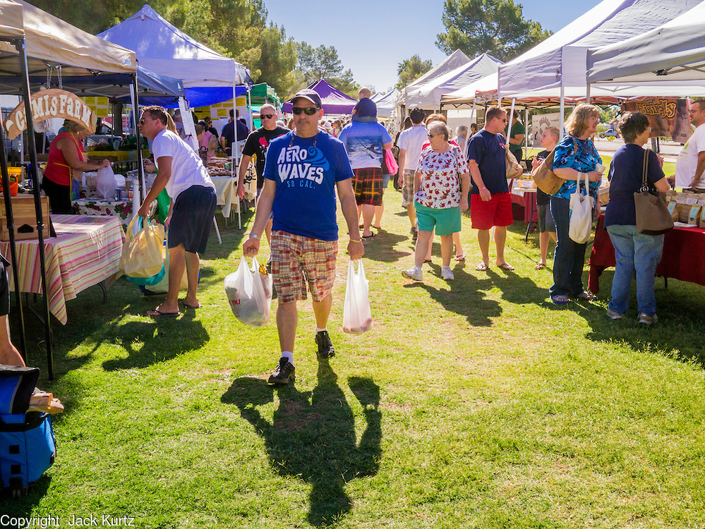 09 JUNE 2012 - PHOENIX, AZ: People walk through the Roadrunner Farmers' Market. The Roadrunner Farmer's Market, in Roadrunner Park in Phoenix, is one of the most popular farmers' markets in the Phoenix area. Unlike many of the other farmers' markets, it's open year round. Most of the vendors in the market are local small scale farmers who practice sustainable agriculture. The market is very popular with "locavores," people interested in eating food that is locally produced and not moved long distances to market. PHOTO BY JACK KURTZ